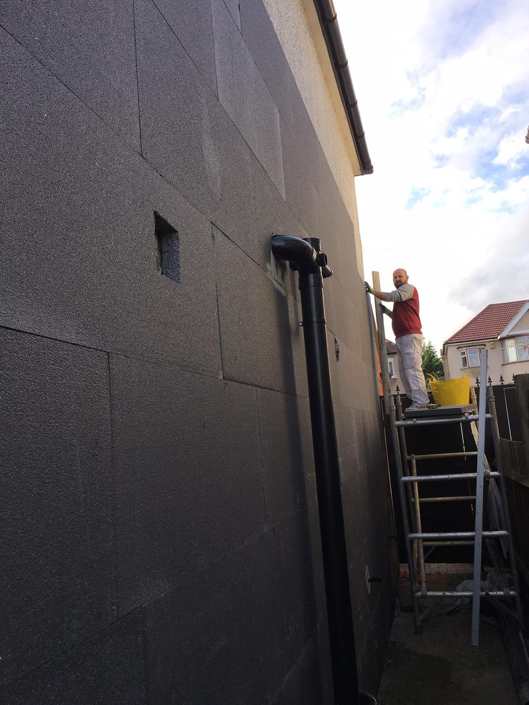 Operative fixing external insulation boards from a scaffold tower